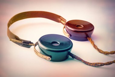 Kumaş telli eski kulaklıklar. Kaliteli kulaklıklar hafif arka planda. Eski radyo mühendisliği kavramı. Seçici yumuşak odak.