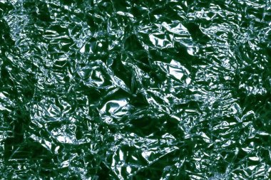 Parlak yüzey. Buruşmuş yeşil folyo. Buruşuk arka plan. Seçici yumuşak odak