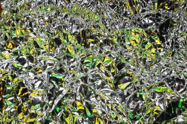 Parlak yüzey. Buruşmuş alüminyum folyo. Buruşuk arka plan. Renkli sim. Seçici yumuşak odak