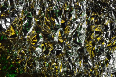 Parlak yüzey. Buruşmuş alüminyum folyo. Buruşuk arka plan. Renkli ışıltı. Yumuşak odak