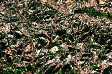 Parlak yüzey. Buruşmuş alüminyum folyo. Buruşuk arka plan. Renkli ışıltı. Yumuşak odak