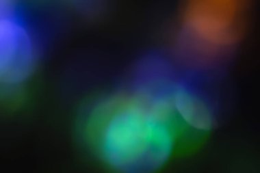 Odaklanmamış neon ışığı. Işıklandırmaların üst üste binmesi. Geleceğin LED ışıklandırması. Karanlık soyut arkaplanda renkli bokeh bulanıklığı