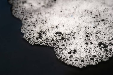 Köpük dokusu. Köpüklü sabun köpüğü. Islak, koyu arkaplanda köpük.