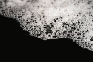 Köpük dokusu. Köpüklü sabun köpüğü. Nemli, koyu bir arka planda köpük.