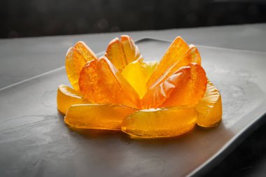 Jöleli şekerler. Citrus denizanaları büyük, siyah bir tabakta