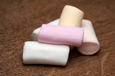 Şekerleme. Ahşap bir yüzeyde bir yığın marşmelov. Yumuşak odak