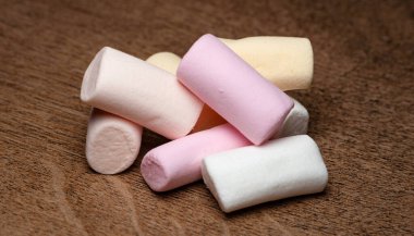 Şekerleme. Ahşap bir yüzeyde bir yığın marşmelov. Seçici yumuşak odak