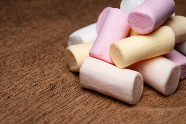 Şekerleme. Ahşap yüzeyde mini marşmelov yığını. Uzayı kopyala Seçici yumuşak odak