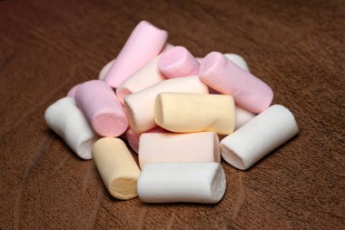 Şekerleme. Ahşap yüzeyde renkli küçük şekerlemeler yığını. Seçici yumuşak odak