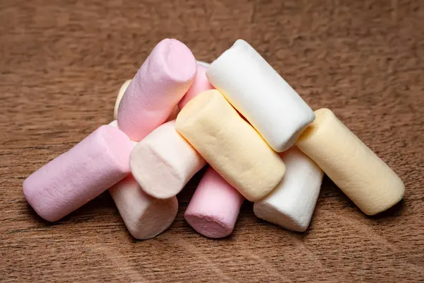 Şekerleme. Ahşap yüzeyde renkli küçük şekerlemeler yığını. Yumuşak odak