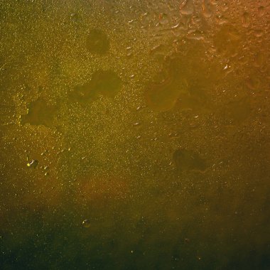 Islak cam. Su koyu cama damlıyor. Soyut doku. Renkli parıltı. Renkli arkaplan
