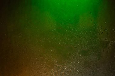 Islak cam. Koyu cama damlatıyor. Soyut doku. Renkli gölgeler. Renkli arkaplan