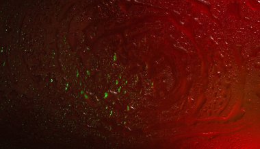 Islak cam. Cama su damlıyor. Soyut koyu kırmızı doku. Hafif noktalar. Renkli duvar kağıdı