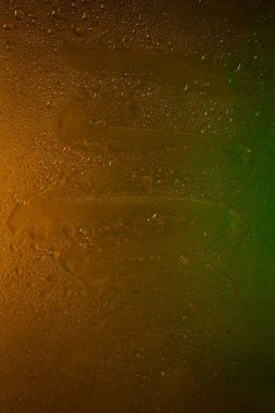 Islak cam. Koyu cama damlatıyor. Soyut doku. Çok renkli röfleler. Renkli arkaplan