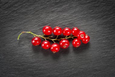 Kırmızı çilek. Frenk üzümü. Koyu arkaplandaki kırmızı böğürtlenlerin üst görüntüsü. Seçici yumuşak odak