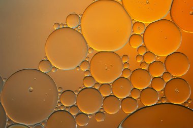 Yağ kabarcıkları. Turuncu tonlarda su üzerinde yağ kabarcıkları. Soyut doku. Makro fotoğrafçılık