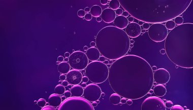 Yağ kabarcıkları. Sudaki yağ baloncuklarına yakın çekim. Mor tonlarda soyut doku. Makro fotoğrafçılık