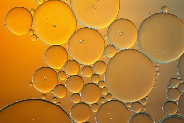 Yağ kabarcıkları. Turuncu tonlarda su üzerindeki yağ kabarcıklarının yakın çekimi. Soyut doku. Makro fotoğrafçılık