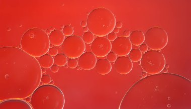 Yağ kabarcıkları. Yağlı baloncuklar suyun üzerinde kırmızı tonlarda yakın çekim. Soyut doku. Makro fotoğrafçılık