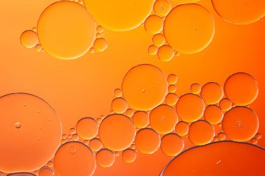 Yağ kabarcıkları. Yağlı baloncuklar turuncu tonlarda suyla kaplıdır. Soyut doku. Makro fotoğrafçılık