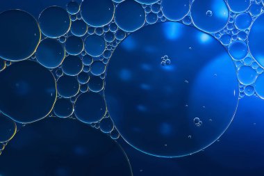 Yağ kabarcıkları. Su üzerinde yağ kabarcıkları. Koyu mavi tonlarda soyut doku. Makro fotoğrafçılık