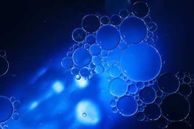 Yağ kabarcıkları. Sudaki yağ baloncuklarına yakın çekim. Mavi renklerde soyut doku. Makro fotoğrafçılık