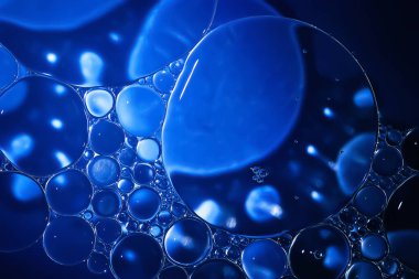 Yağ kabarcıkları. Su üzerinde yağ kabarcıkları. Mavi renklerde soyut doku. Makro fotoğrafçılık