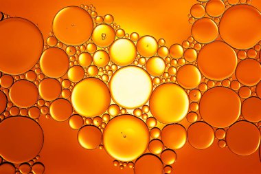 Yağ kabarcıkları. Sudaki yağ baloncuklarına yakın çekim. Altın tonlarda soyut dokular. Makro fotoğrafçılık