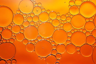Yağ kabarcıkları. Su üzerinde yağ kabarcıkları. Altın tonlarda soyut dokular. Makro fotoğrafçılık
