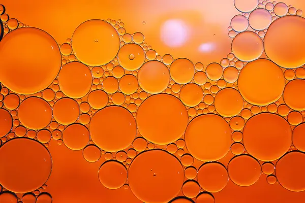 Yağ kabarcıkları. Sudaki yağ baloncuklarına yakın çekim. Altın renkli soyut dokular. Makro fotoğrafçılık