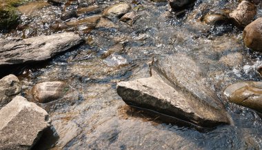 Dağ nehri. Hızlı hareket eden suda büyük kayalar. Parlak ıslak taşların dokusu. Dağlarda seyahat et.