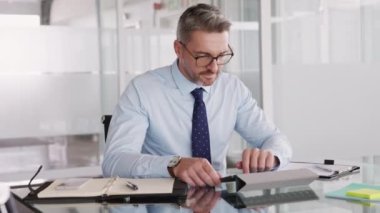 Olgun iş adamı iş yerinde dijital tablet kullanıyor. Modern bir ofiste bilgisayar üzerinde çalışan sakin bir iş adamı. Orta yaşlı resmi görevli e- postaları kontrol ediyor.