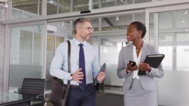 Gülümseyen olgun iş adamı ve Afro-Amerikan iş kadını ofisten çıkıyorlar. İki mutlu çok ırklı iş arkadaşı işten eve giderken konuşuyor. Modern ofiste başarılı iş adamları birbirleriyle konuşuyor..
