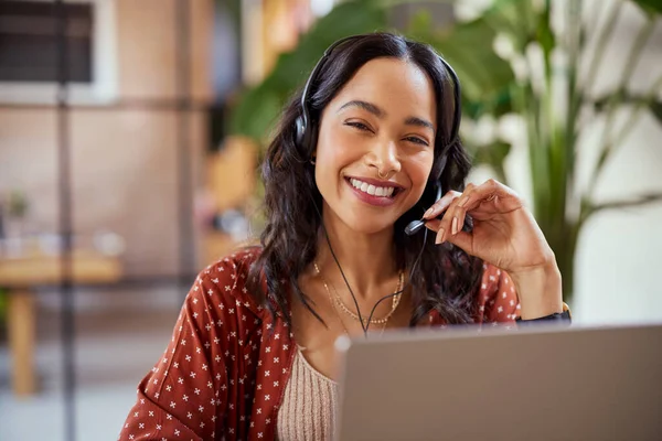在有创意的办公室工作的女商人笑着 微笑友善的女性作为呼叫中心的代理人为在线支持工作 混合种族女孩在视频电话与耳机看着相机与复制空间 免版税图库照片
