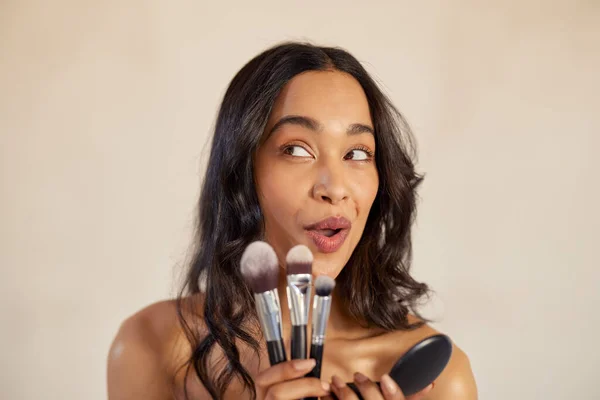 Młoda Latynoska Robi Śmieszne Miny Trzymając Pędzle Kosmetyczne Makijażu Fundacji Zdjęcie Stockowe