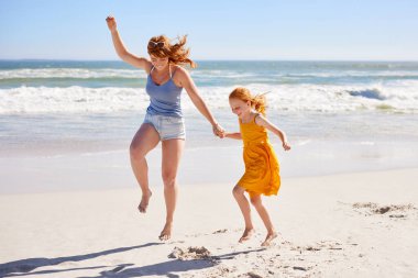 Mutlu komik anne ve kızı fotokopi odasıyla yaz plajında zıplıyorlar. Neşeli anne, deniz kenarında kızıl saçlı şirin bir kızla dans ediyor. Mutlu abla okyanus kıyısında çocukla eğleniyor..