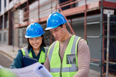 Mühendisler bir inşaat alanının planlarını birlikte analiz ediyorlar. İnşaat ekibi mimari planları dikkatle inceliyor. Mimari ekip üyeleri proje detaylarını özel bir toplantıda tartışıyor.