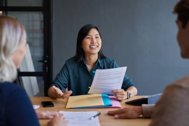 Bir iş görüşmesinde nitelikleri tartışan gülümseyen aday. Profesyonel bir görüşme sırasında özgeçmiş sunan kendinden emin bir kadın. Yatırım sunan mali danışman ve çift için tasarruf olanağı.
