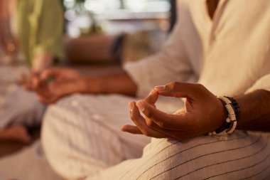 Grup iyileştirme seansı sırasında meditasyon yapan Mudra 'ya el atın. Huzurlu bir farkındalık ve nefes alma anı kapalı bir sağlık inzivasına çekildi. Nilüfer pozisyonunda sakin bir enerjiyle el dinleniyor..