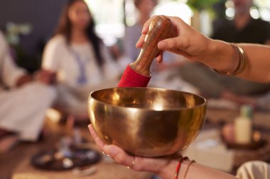 Fotokopi odasıyla grup meditasyonu sırasında kadınların ellerinin müzik çanağı çalmasını kapatın. Kapalı alandaki sağIık inzivasında şifa ve enerji çalışması için kullanılan pirinç ses kasesi. Tibet çanları ile huzurlu ruhani uygulamalar.