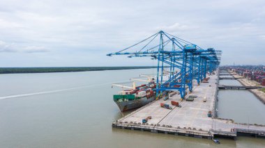 Klang, Malaysia - October 09, 2022: Cranes at the port Klang near Kuala Lumpur. Container crane at Klang Harbor. Aerial view on a container ship which is being loaded. Heavy Trucks at the Cargo bay clipart