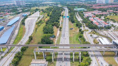 Malezya - 9 Ekim 2022: demiryolu köprüsü olan bir otoyolun havadan görünüşü. Asfalt yolun üst manzarası tren yolu ile kesişiyor. Trafik taşıma altyapısı. Üstten görüntülü otoyol.