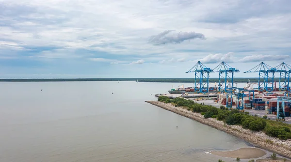 stock image Klang, Malaysia - October 09, 2022: Cranes at the port Klang near Kuala Lumpur. Container crane at Klang Harbor. Aerial view on a container ship which is being loaded. Heavy Trucks at the Cargo bay