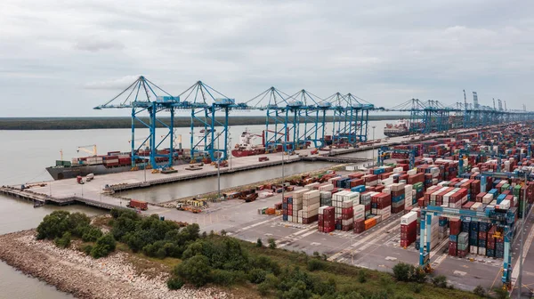 stock image Klang, Malaysia - October 09, 2022: Cranes at the port Klang near Kuala Lumpur. Container crane at Klang Harbor. Aerial view on a container ship which is being loaded. Heavy Trucks at the Cargo bay