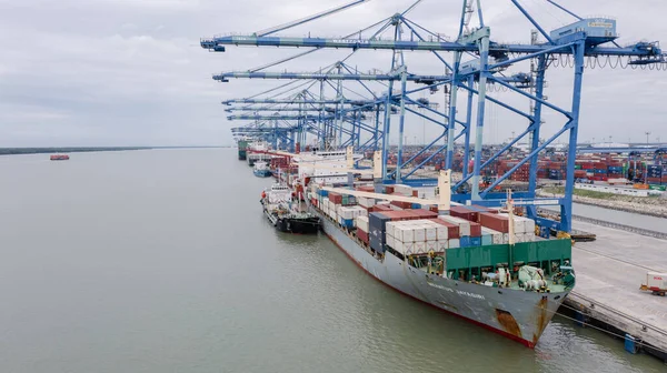 stock image Klang, Malaysia - October 09, 2022: Cranes at the port Klang near Kuala Lumpur. Container crane at Klang Harbor. Aerial view on a container ship which is being loaded. Heavy Trucks at the Cargo bay