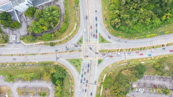 stock image Traffic junctions, modern city. View from above to busy road junction in Malaysia. Colorful cars and trucks driving straight forward in both directions crossing the road. Aerial view of road crossing