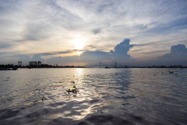 Ho Chi Minh City yakınlarındaki Mekong deltasında gün batımı. Büyük bulut oluşumları batan güneşin önüne itiyor. Gece vakti Mekong Nehri 'nde. Saigon yakınlarında büyük bir nehirde dramatik bir gökyüzü. Batan güneş
