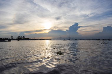 Ho Chi Minh City yakınlarındaki Mekong deltasında gün batımı. Büyük bulut oluşumları batan güneşin önüne itiyor. Gece vakti Mekong Nehri 'nde. Saigon yakınlarında büyük bir nehirde dramatik bir gökyüzü. Batan güneş