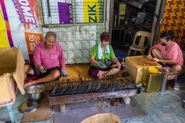 Pulau Ketam, Malezya - 26 Aralık 2022: Pulau Ketam, Klang açıklarındaki küçük ada anlamına gelir. Yaşlı bir çift yerel gofret yapıyor, kızarmış dondurmadan sonra, başka bir popüler yemek.