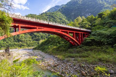Shakadang Köprüsü, Taroko Ulusal Parkı Tayvan 'ındaki Shakadang Patikası' nın girişindeki Liwu Nehri üzerinde. Kırmızı çelik köprü kristal akıntısını geçiyor.